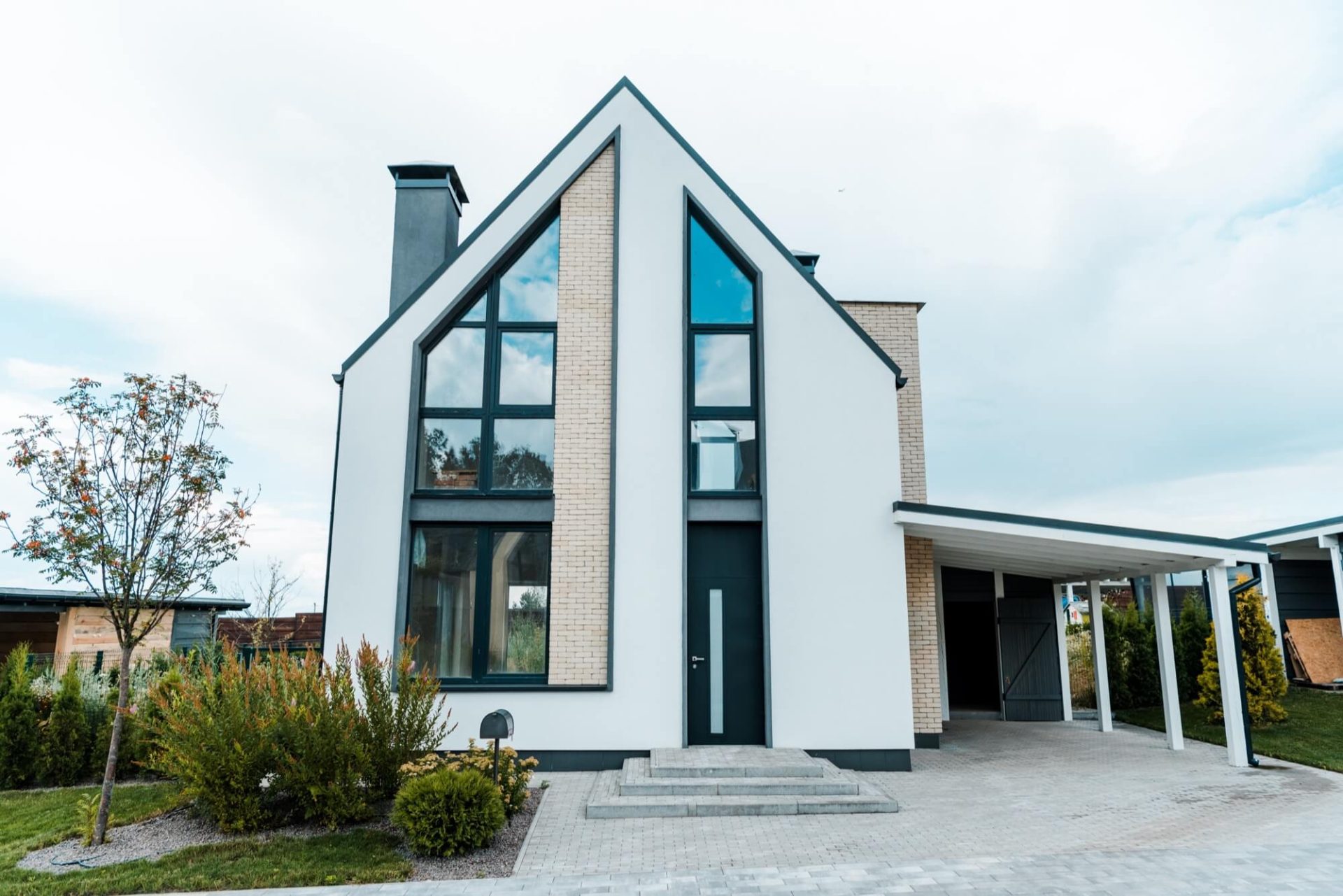 Denna moderna villa har renoverats med fokus på ljusinsläpp genom stora glaspartier, kompletterat med ett svart tak och en designad uppfart